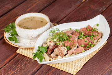  an appetizing meat dish with soup, beautifully laid out with vegetables, for use in design