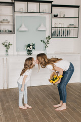  little girl gives flowers to mother on March 8