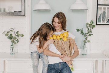  little girl gives flowers to mother on March 8