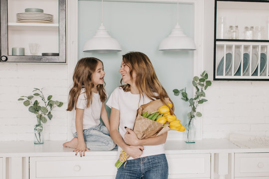 little girl gives flowers to mother on March 8