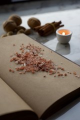 Vintage book with empty pages, near the window, with candle and spices