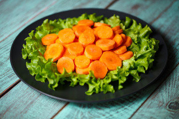 carrot sliced ​​on a plate and wooden background