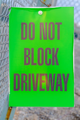 Do Not Block Driveway sign on a mesh wire fence
