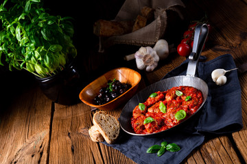 Baked mini meatballs in tomato sauce with basil
