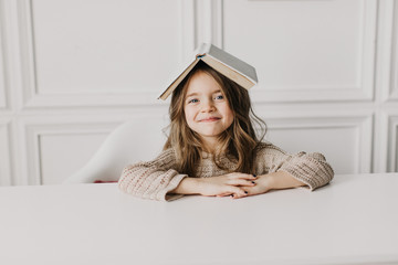 little beautiful girl doing homework: reading a book