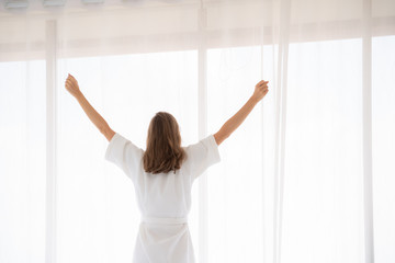 pregnancy, motherhood, people and expectation concept - close up of happy pregnant woman opening window curtains.