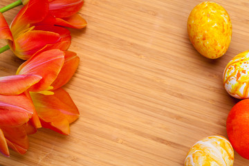 Easter eggs with tulips on wooden board, easter holiday concept. Copyspace for text