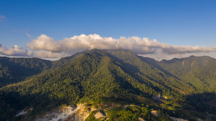 The cloud above the green mountain range. Arial shot, top view