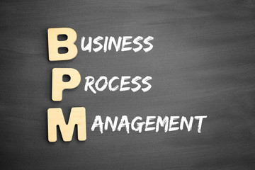 Wooden alphabets building the word BPM - Business Process Management acronym on blackboard