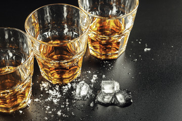 Whiskey and ice on rustic wood background