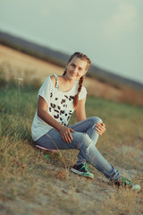 Young happy cute girl rides skateboard on road, outdoor