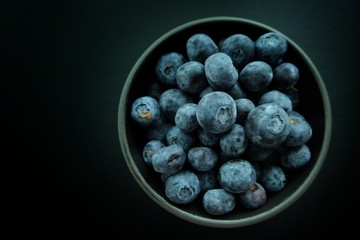 Blueberries on black plate and black background. 