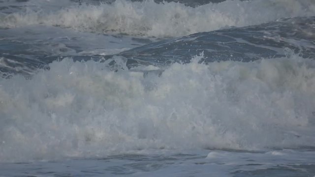 Waves rolling on the beach is a stormy day, winter mediterranean sea. Focene, Lazio, Italy. Slow motion