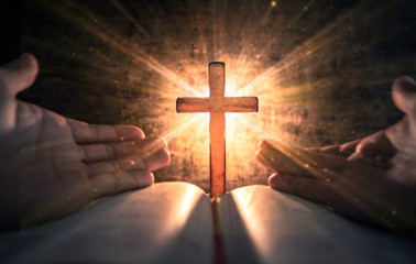 Pray hands with light the cross on bible in worship room. christian praying concept. - obrazy, fototapety, plakaty