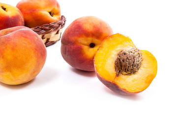 Naklejka na ściany i meble Whole and half of ripe peach fruit and several in basket isolated on white background.