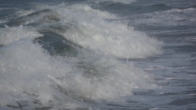 Waves rolling on the beach is a stormy day, winter mediterranean sea. Focene, Lazio, Italy. Slow motion
