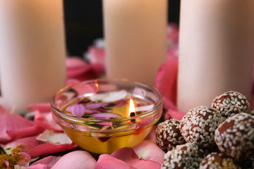 Bowl with oil, burning candle and flower petals for celebration of Divaly on table