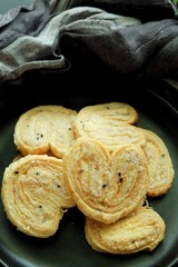 Butterfly cookies on black plate and black background. 