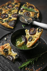 Tasty Italian focaccia with basil sauce on table