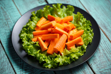 carrot sliced ​​on a plate and wooden background