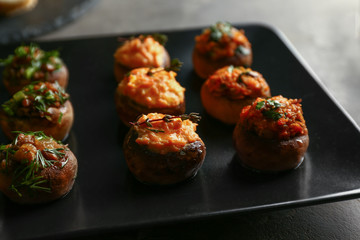 Tasty stuffed mushrooms on plate, closeup