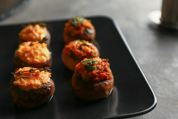 Tasty stuffed mushrooms on plate, closeup