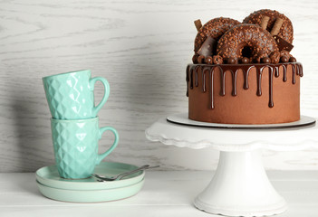 Stand with sweet chocolate cake on white table