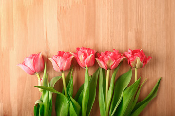 Beautiful fresh tulips on wooden background