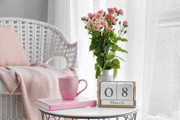 Bouquet of beautiful flowers, book, cup of coffee and calendar with date 8 MARCH on table....