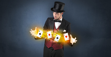 Illusionist in tails bandy play cards between his two hands