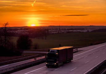 Fototapeta na wymiar Lkw auf der Autobahn bei Sonnenuntergang