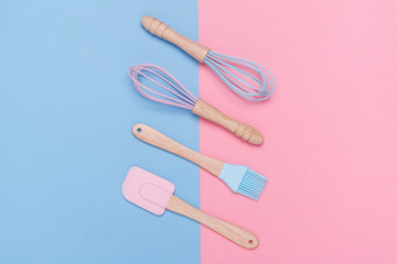 pastel colored whisk, spatula, and pastry brush on a pastel pink and blue background. Minimal style. 