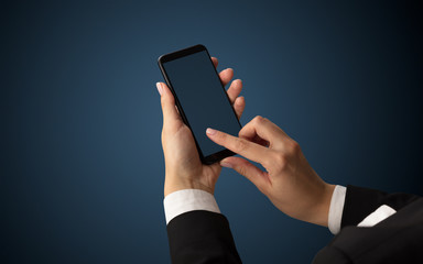 Mockup for female hand using frameless smartphone with dark background
