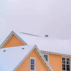 Snowy roof of home in Daybreak with sky background