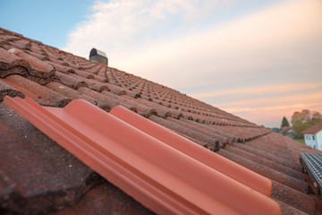 Altes Hausdach mit roten Dachschindeln, neuer Dachziegel zum Austausch