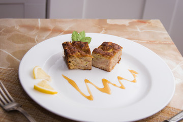 Two pieces of a tuna casserole on a decorated plate.