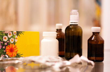 Bottles with medical drugs and medicinal herbs on the glass table.
