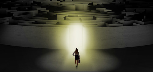 Woman getting ready to enter a concentric labyrinth with lighted entrance concept
