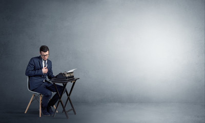 Man working hard on a typewriter in an empty space
