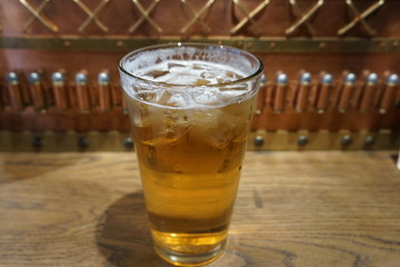 Delicious beautiful ice cold ice tube jar of beer glass on wooden table in vintage bar top view close up brew beer with white foam fresh beverage on summer time alcohol party 