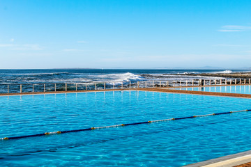 Fototapeta na wymiar Sea Point Pavilion, an outdoor swimming pool with sea salt water and a stunning view on the Atlantic Ocean in Cape Town, South Africa