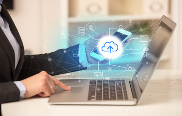 Business woman in homey environment using laptop with  online storage and cloud technology concept
