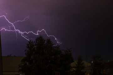 Lightning in the night sky over the houses