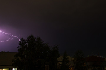 Fototapeta premium Lightning in the night sky over the houses
