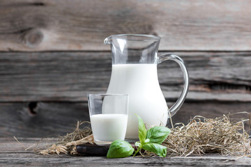 Fresh milk in glasses in front of a rustic vintage background - 252210003