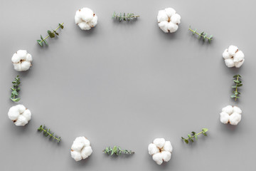 Flowers frame with fresh eucalyptus branches and cotton on grey background top view space for text