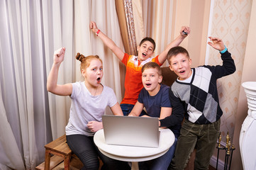 Group of happy kids with joyful emotions have a fun with laptop computer. Education, fun, children, technology, people concept