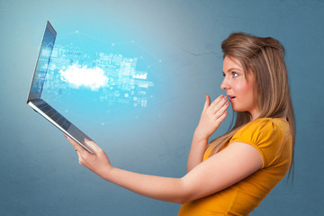 Woman holding laptop projecting notifications, symbols and information based on cloud technology system
