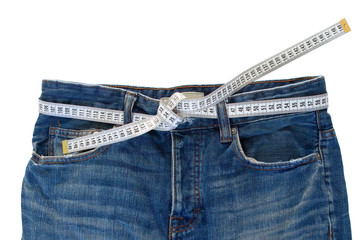 Jeans with a measuring tape on a green background. Weight loss concept