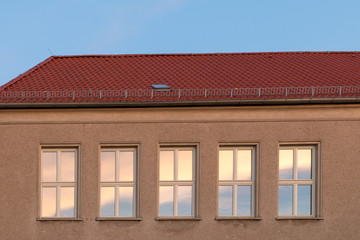 several windows on a house wall in sunny weather